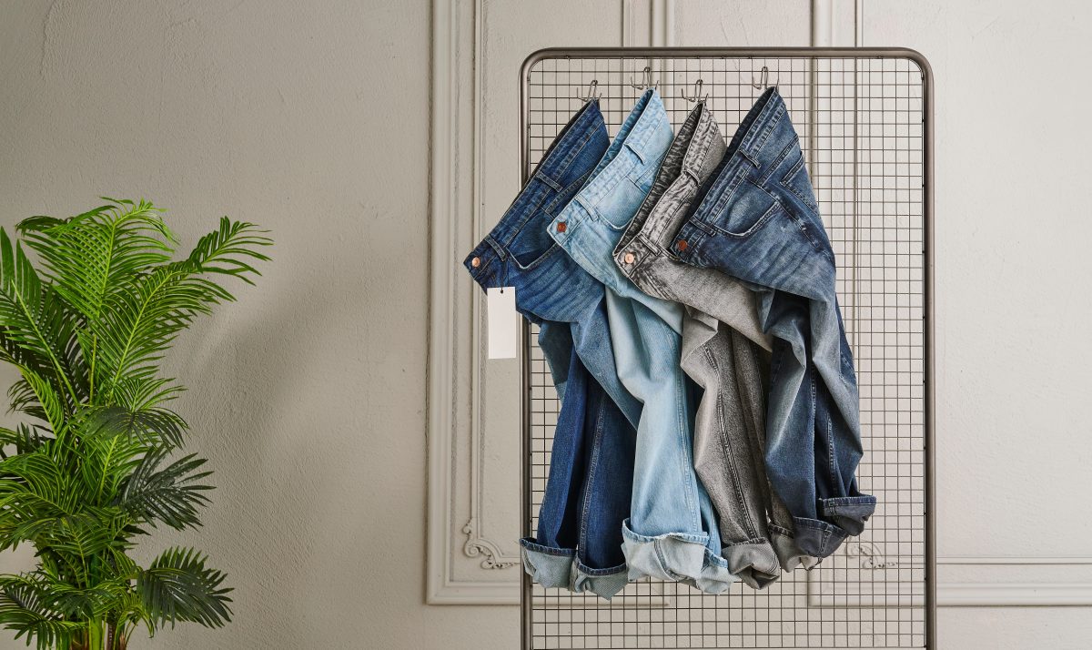 Four jeans pants hung on a rack